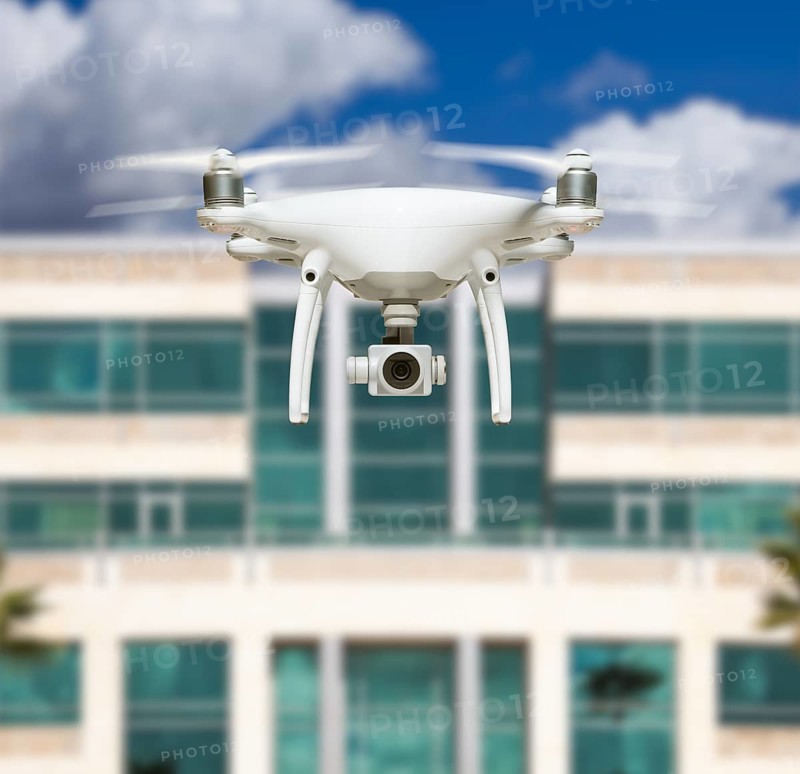 Unmanned Aircraft System Quadcopter Drone In The Air Near City and Corporate Building