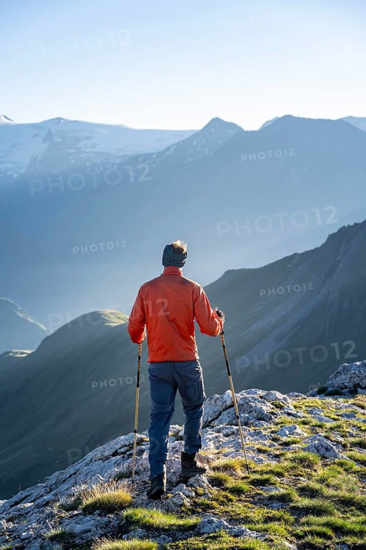 Hiker enjoying the mountain panorama in the morning, Venediger group, behind Dreiherrenkopf, Simonysitze and Großer Geiger, Hohen Tauern, Austria