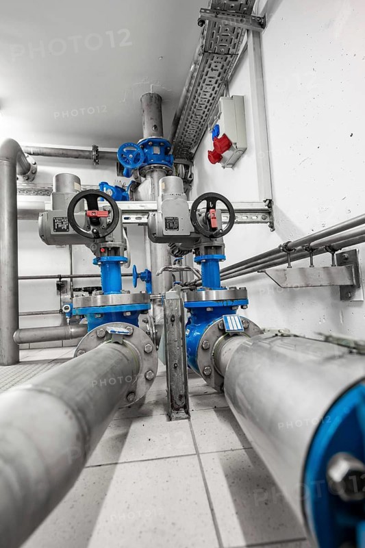 Pipes and valves in a precise arrangement within an industrial space, ENCW Netze Calw waterworks, Calw, Black Forest, Germany