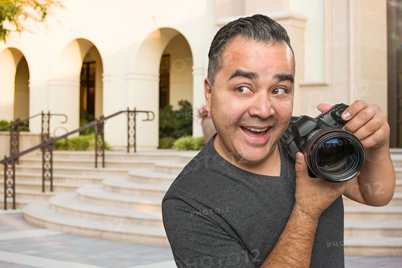 Hispanic Young Male Photographer With DSLR Camera Outdoors