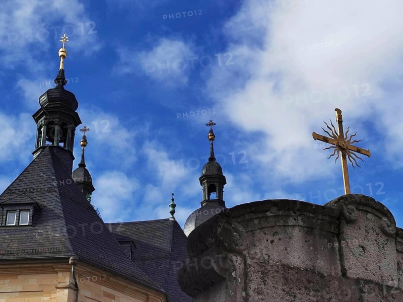 Church towers and a cross against a blue sky with clouds, Gößweinstein, Franconian Switzerland