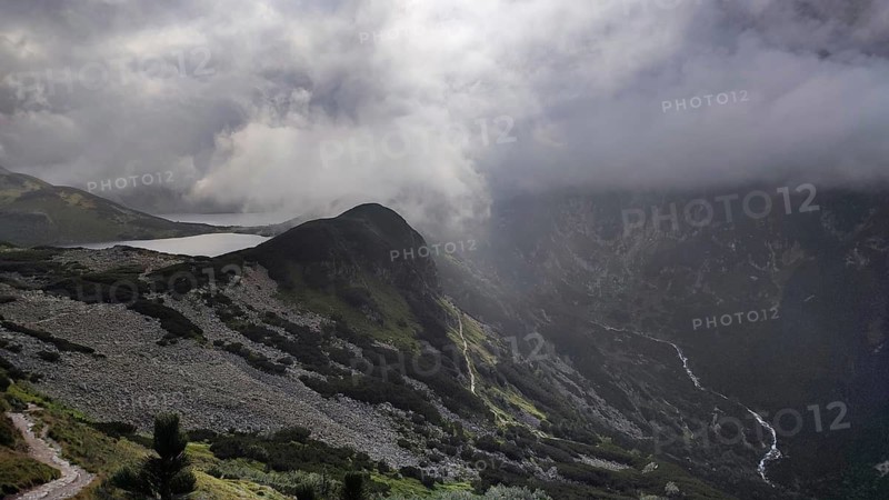 Mountain landscape with dramatic clouds and light over a valley, Zakopane, Morskie Oko hiking in the High Tatras National Park, Carpathian Mountains, Poland