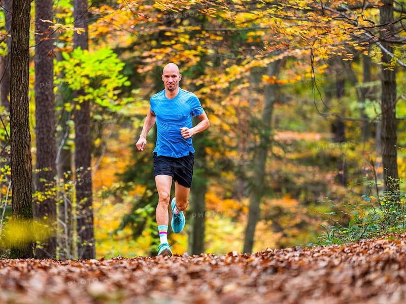 Man in a training session, trail running outdoors, healthy lifestyle, colorful autumn forest, Swabian forest, valley Remstal, Germany