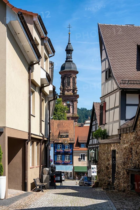 Old town alleyway with half-timbered buildings in Gengenbach with the town church of St Mary, Ortenaukreis, Baden-Württemberg, Germany