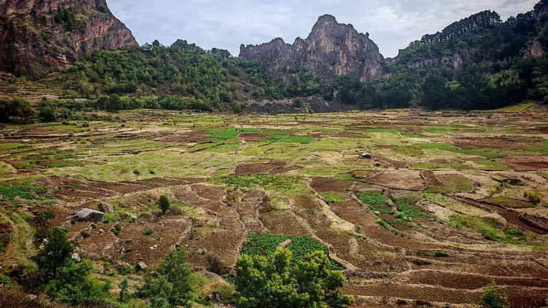 Panorama, vast terraced fields in the caldera from the Cova volcano, nestled in a mountainous landscape under cloudy sky, hiking from the Cova volcano crater through the Paul Valley, Ribeira do Paul to Vila das Pombas, Santo Antao, Cabo Verde, Cape Verde, Cape Verde