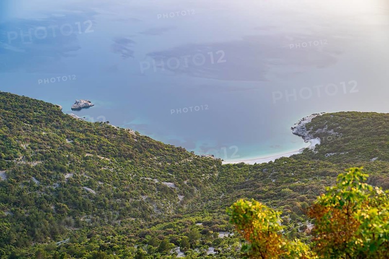 View from Lubenice across the sea with coastal landscape and bays on a sunny day at sunset on the island of Cres, Croatia
