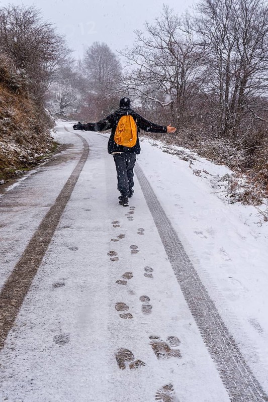 A young man enjoying himself on the snowy road of gipuzkoa's mount aizkorri. Snowy landscape by winter snows. Basque Country, Spain