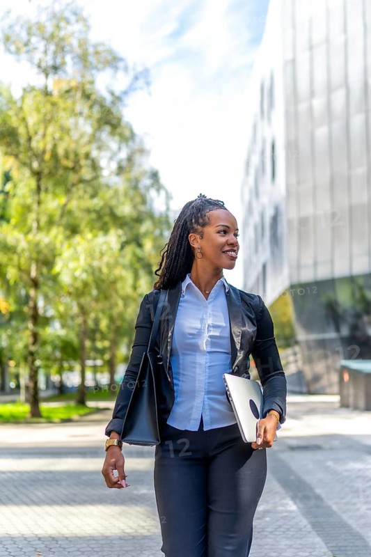 Vertical photo of a stylish latin businesswoman walking along the city