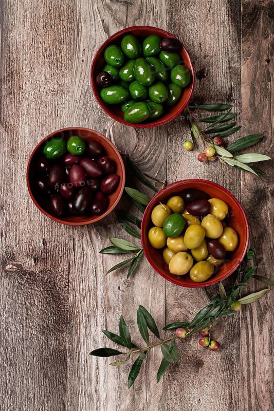 A mixture of olives, varieties of chalkidiki, Verdi giganti and Kalamata, in a bowl, top view, no people