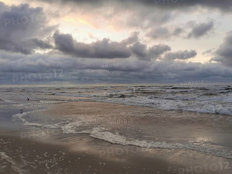 Dramatic cloud formations over the ocean at sunset with reflecting water