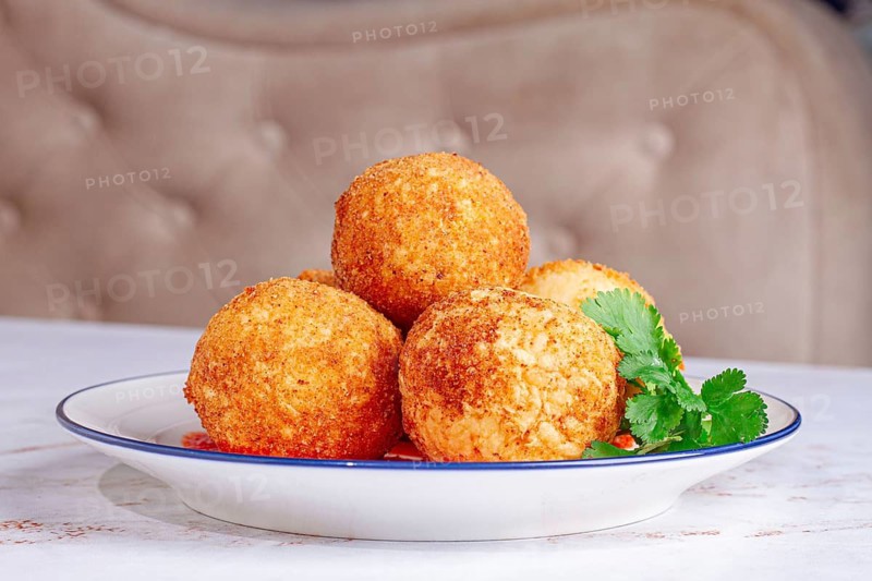 Arancini appetizer with tomato sauce, on a white plate, homemade, no people