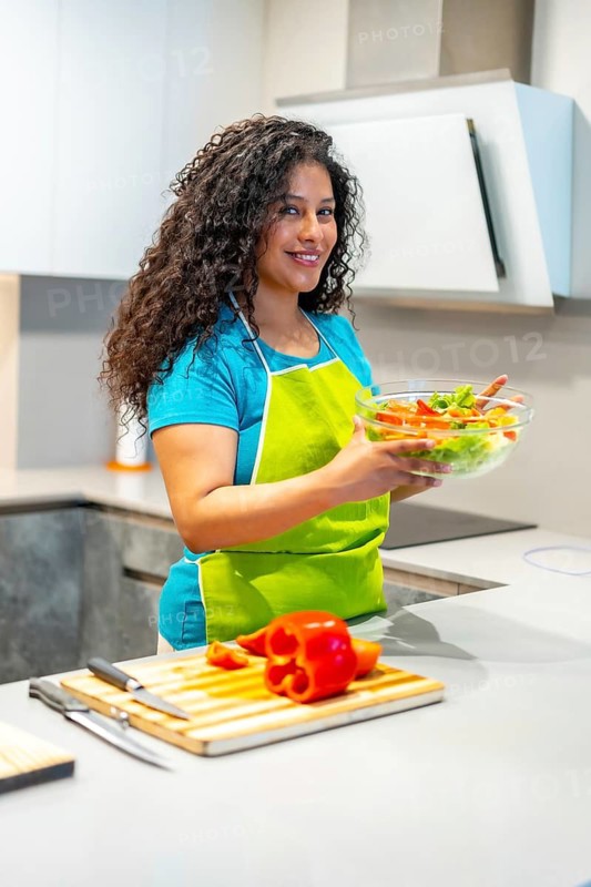 Vertical photo of a latin attractive woman recording a video blog teaching how to prepare healthy food