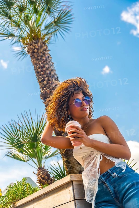 Vertical photo of a sensual woman drinking iced shake outdoors in a sunny day in summer