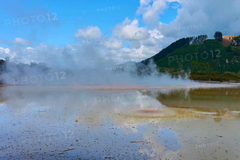 A steaming lake with surrounding mountains and clouds in the sky, Champagne Pool thermal lake, Wai-O-Tapu Thermal Wonderland, Rotorua, North Island, New Zealand