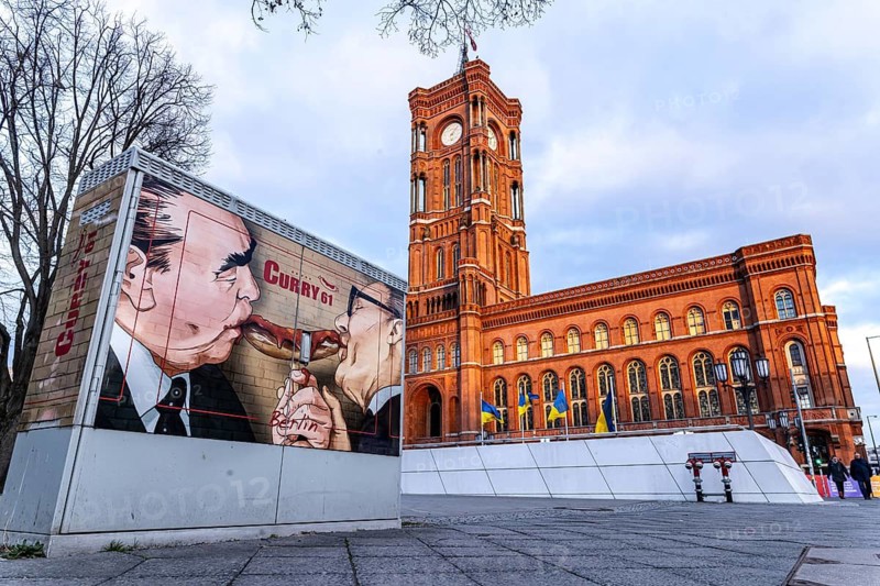 Red Town Hall in Berlin. Advertisement for the fast food chain Curry 61. Portrait of Erich Honecker and Leonid Ilyich Brezhnev sharing a curry sausage. Berlin, Germany
