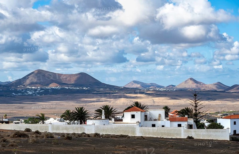 Volcanic landscape with volcanic cone, white houses in the village of Teguise, Lanzarote, Canary Islands, Spain
