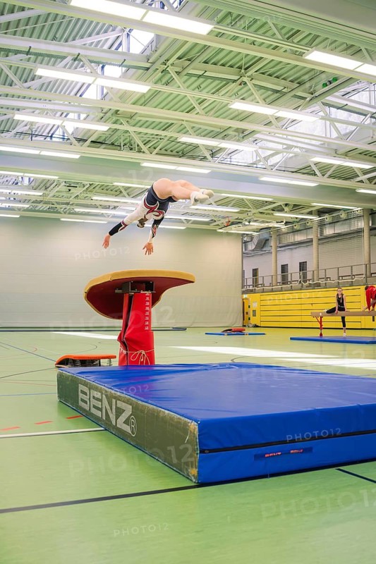A gymnast in the air jumping off a horse jumping device in a gym, Gymnastics, Calw, Germany