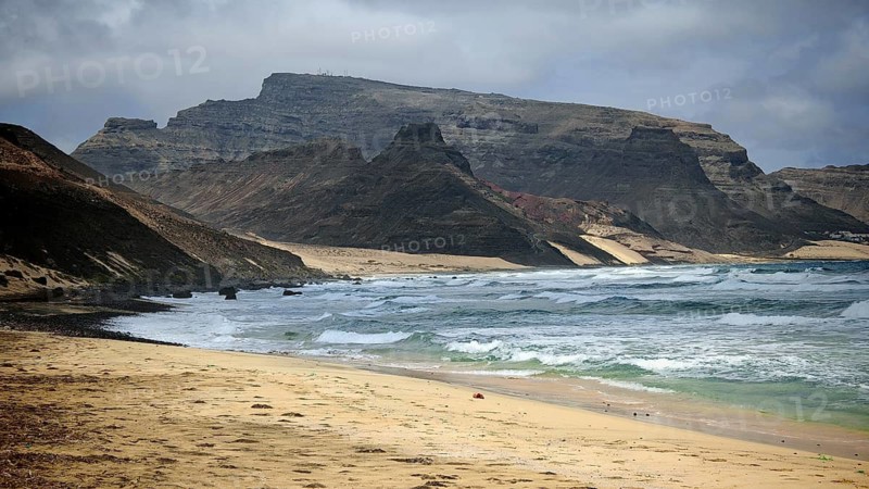 Secluded, secluded coast with sandy beach and rock formations that look out to sea under grey skies, hiking Calhau, Baia das Gatas, Sao Vicente, Cabo Verde, Cape Verde, Cape Verde