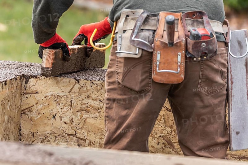 Construction Worker Leveling Wet Cement Into Wood Framing
