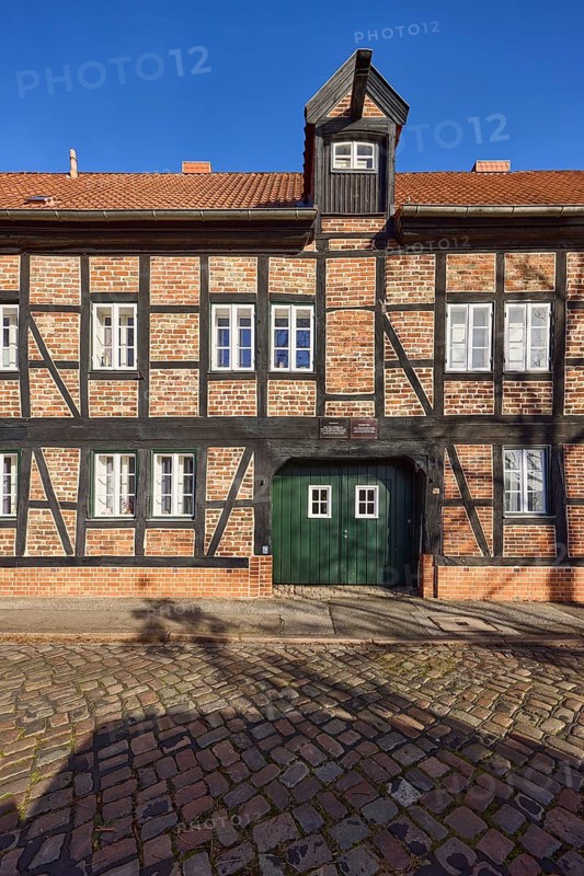 Rossmühle, half-timbered house, dormer with crane, entrance gate, blue cloudless sky, cobblestone street An der Obertrave, Old Town, Hanseatic City of Lübeck, independent city, Schleswig-Holstein, Germany