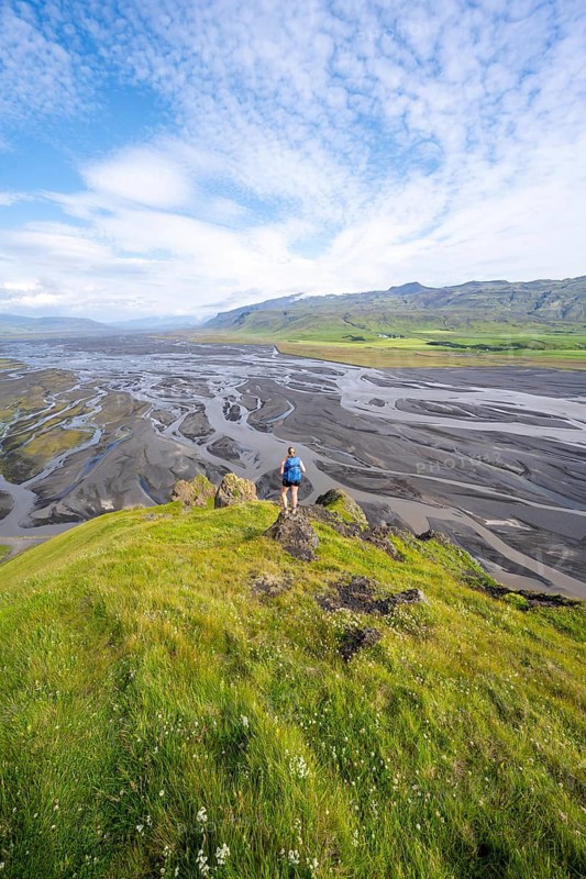 Hiker, Young woman on a hill, view over alluvial land, meandering river, Dímonarhellir, Suðurland, Iceland
