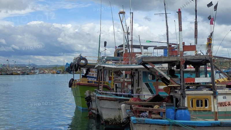 Various colorful fishing boats are lying on the water in the harbor, Sri Lanka