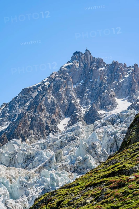Glacier ice of the Glacier des Bossons, behind pointed mountain peaks, Chamonix, Haute-Savoie, France