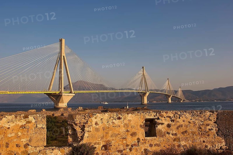 Wide view of a modern bridge that stretches majestically across the Gulf of Corinth, with ruins in the foreground, Rio-Antirrio cable bridge, Rio fortress, Patras, Peloponnese, Greece