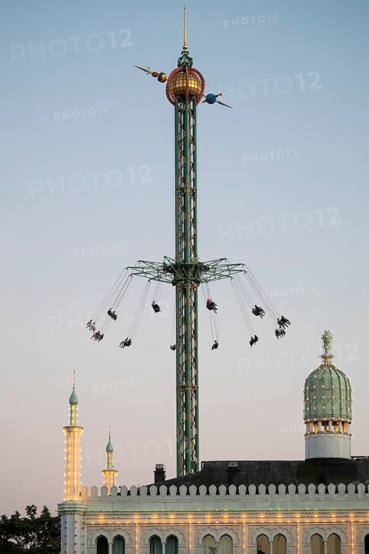 Star Flyer chain carousel at dusk, illuminated Nimb Restaurant, Tivoli Amusement and Recreation Park, Copenhagen, Denmark