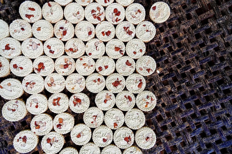 A close-up photo of traditional Macau almond cookies sprinkled with ground almonds and placed neatly on a mesh tray, showcasing their delicate patterns and ingredients
