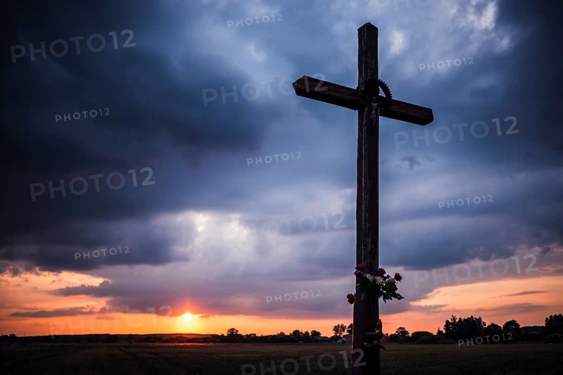 Wayside crucifix and sunset in the background in Tymowa, Poland