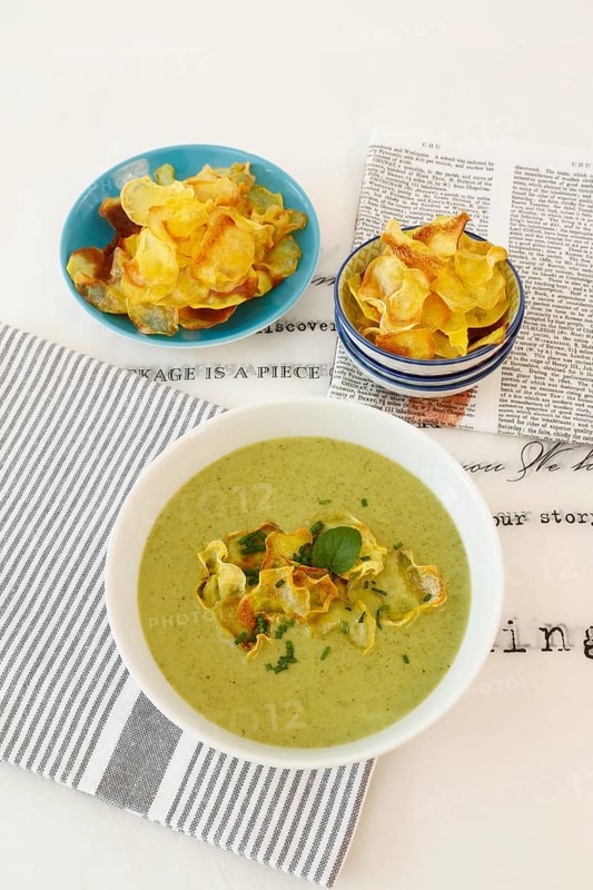 Swabian cuisine, cress soup with crisps, cress, plate with green cream soup, soup bowl, garnished with herbs, hearty soup, bowl with crisps, tea towel, writing, letters, vegetarian, healthy, salty, cooking, typical Swabian reinterpreted, traditional cuisine, food photography, studio, tablecloth, Germany