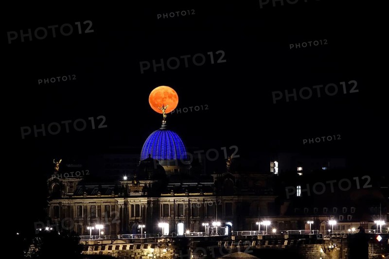 Glowing strawberry moon on 11 June 2025 over the Dresden University of the Arts, Saxony, Germany