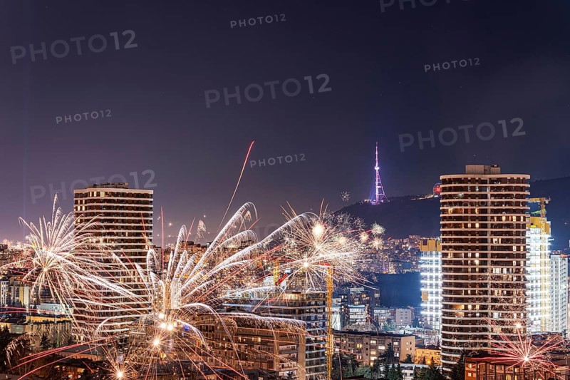 Captivating view of Tbilisi downtown at night, highlighted by vibrant fireworks lighting up the skyline, creating a festive and dynamic urban atmosphere