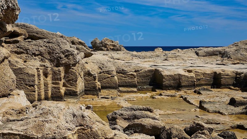 Rough rocky landscape by the sea under a sunny sky, Oasis Beach, East Coast Rhodes, Rhodes, Dodecanese, Greek Islands, Greece