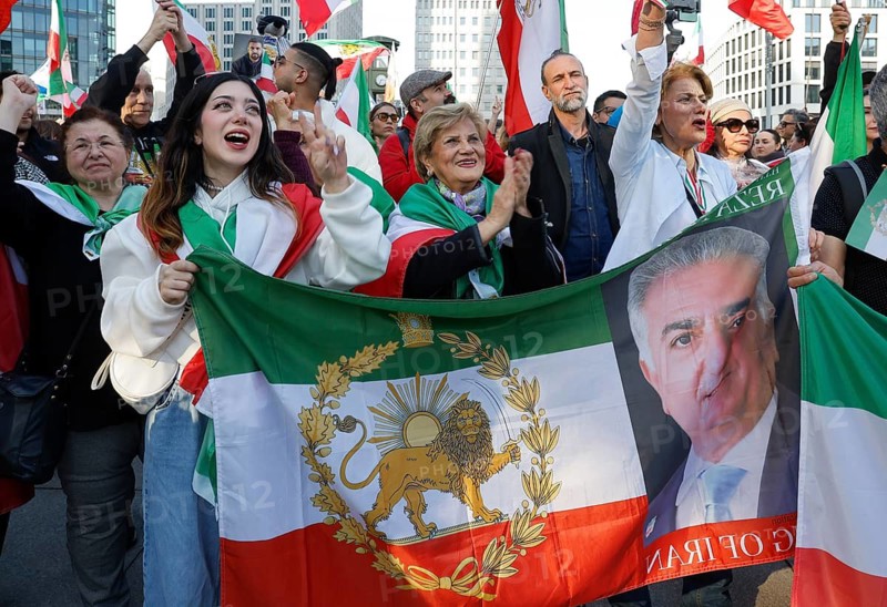 Iranians demonstrate with a poster of Prince Reza Pahlavi on the day of the US and Israeli attack on Iran, Berlin, 28.02.2026. People wave flags of the Iranian monarchy, German, Israeli and US flags, Berlin, Berlin, Germany
