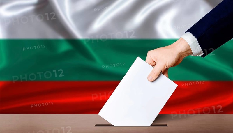 Bulgaria Parliamentary vote. Hand placing a ballot in ballot box with the Bulgarian flag in the background