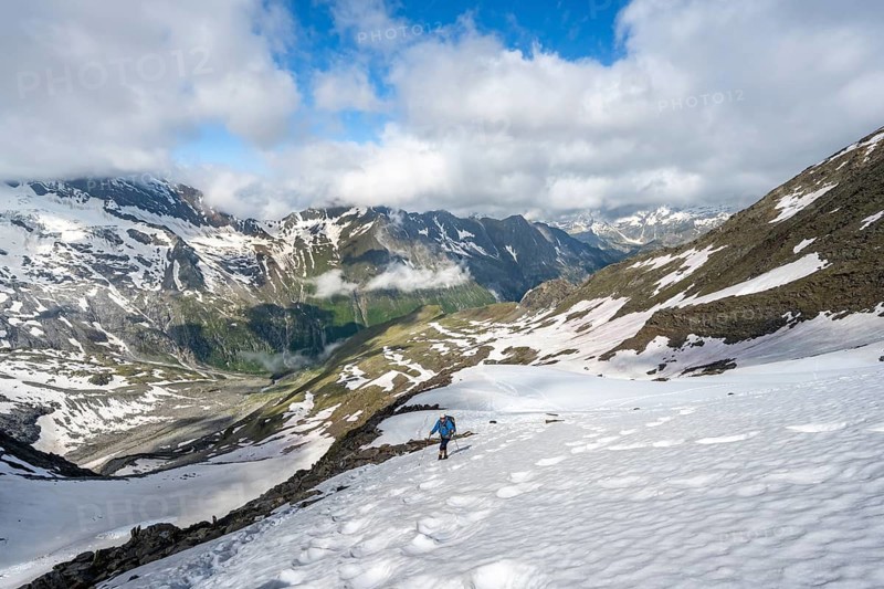 Mountaineer on hiking trail with snow, mountain landscape with summit Hoher Weißzint and Hochsteller with glacier Schlegeiskees, Berliner Höhenweg, Zillertal Alps, Tyrol, Austria
