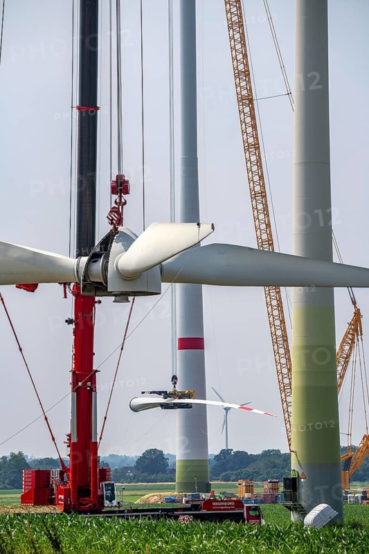 Dismantling of a wind power plant in a wind farm near Issum, 9 older wind turbines from the manufacturer Enercon (model series E-58), front, blades being dismantled, were in operation for over two decades, will be replaced by a total of four Enercon E-160 turbines, rear, assembly of the first blade, with a total output of 22 megawatts, Lower Rhine, North Rhine-Westphalia, Germany
