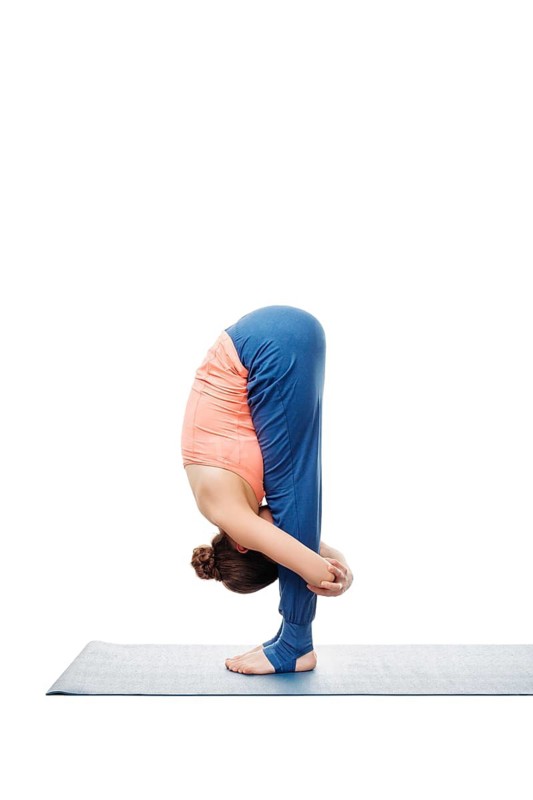 Woman doing Ashtanga Vinyasa Yoga Surya Namaskar Sun Salutation asana uttanasana, standing forward bend pose posture isolated on white background