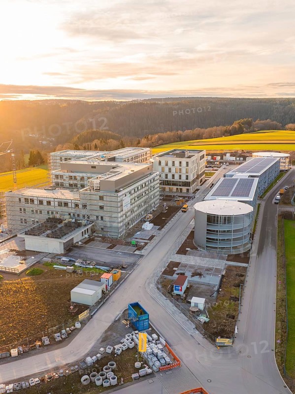 Sunset over an extensive industrial construction area in a rural landscape, new construction of the Calw Health Campus, Calw district, Black Forest, Germany