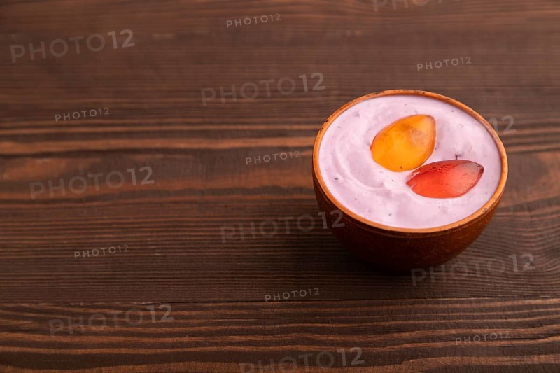 Purple Yogurt, with jelly candy on brown wooden background, side view, copy space, minimalism