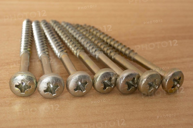 Phillips screws on wooden background, wood screws