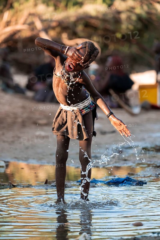 Himba child washing with water on a river, traditional Himba, Kaokoveld, Kunene, Namibia