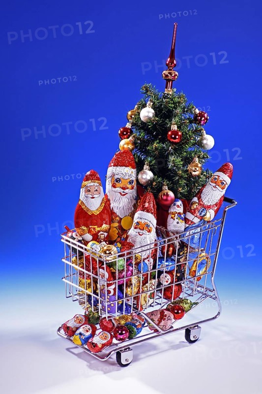 A shopping trolley with Christmas articles, chocolate, sweets Studio shot, Lower Saxony, Federal Republic of Germany