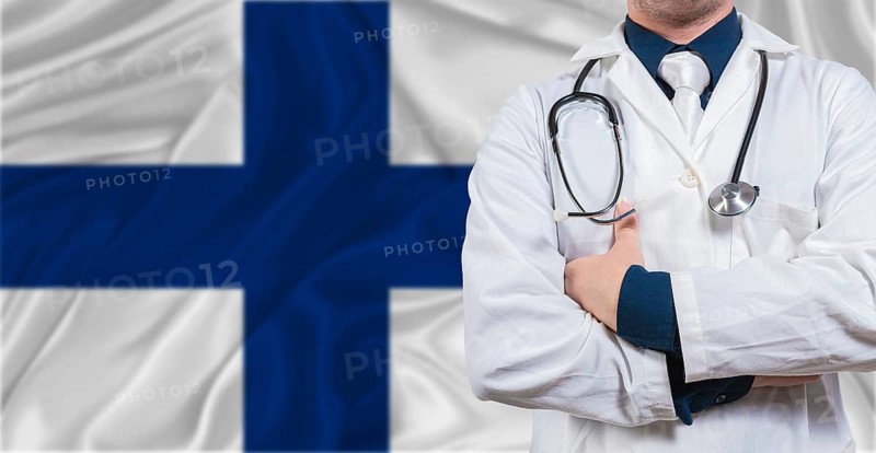 Male doctor with stethoscope on Finland flag. Doctor holding stethoscope on Finland flag