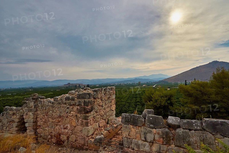 Stone walls and ruins with a cloudy sky and mountains in the distance, Tiryns, ancient city in Argolis, Mycenaean, Peloponnese, Greece