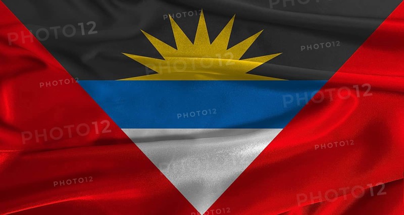 Flag of Antigua and Barbuda with fabric textured background. Close up of National flag of Antigua and Barbuda with realistic texture