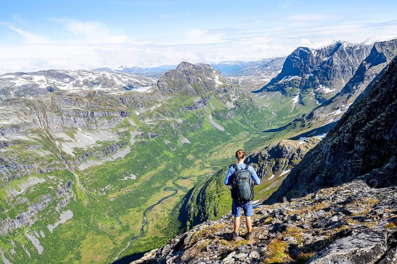 Mountaineers in front of mountainous landscape at the summit of Innerdalstårnet, view of Innerdalen high valley, Trollheimen Mountain Area, Sunndal, Møre og Romsda, Vestlandet, Norway
