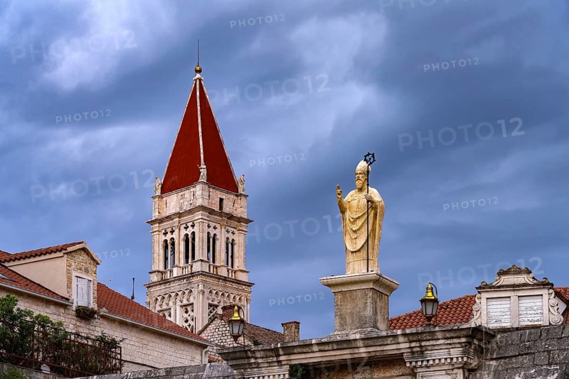 Statue of the patron saint Ivan Ursini on the city gate and the tower of the Cathedral of St Lawrence in Trogir, Croatia